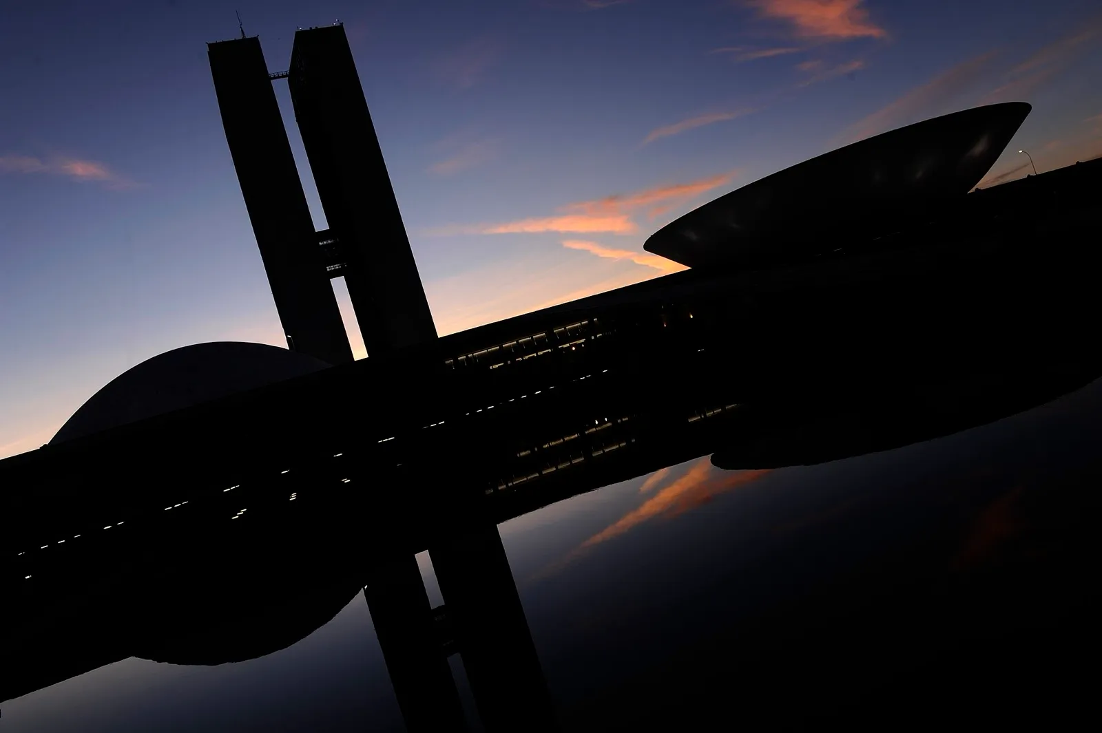 Silhueta do Palácio do Congresso Nacional, em Brasília, com as duas torres e as cúpulas ao amanhecer