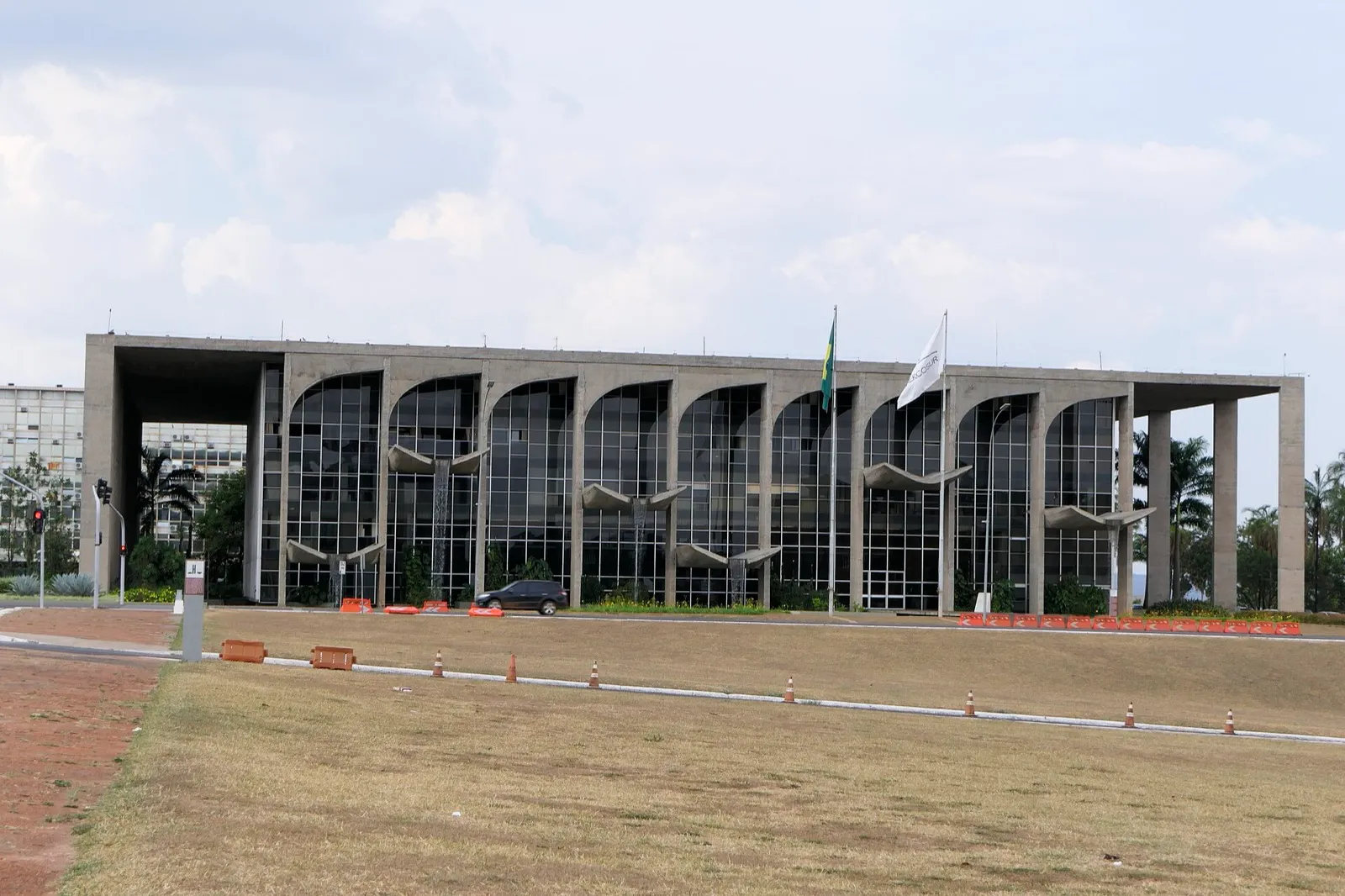 Fachada de concreto e vidro do Palácio da Justiça, em Brasília, com a bandeira do Brasil hasteada ao lado do prédio